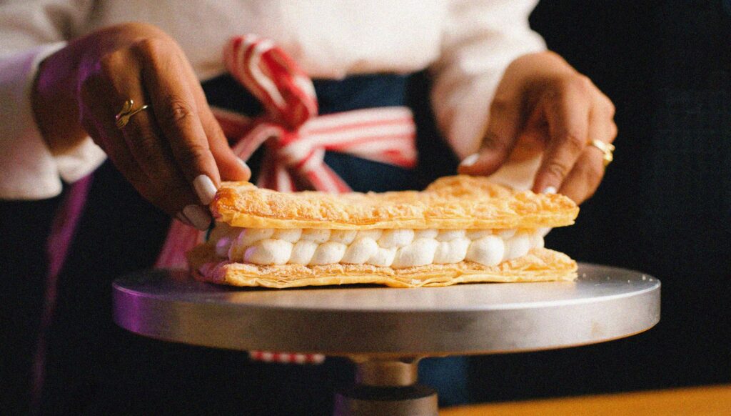 montage d'un mille-feuille sur un présentoir en pâtisserie