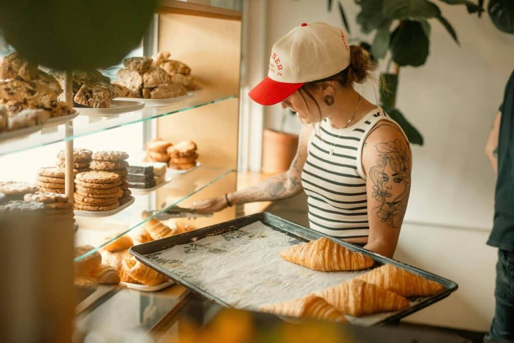 Boulangère disposant des croissants en vitrine dans une boulangerie