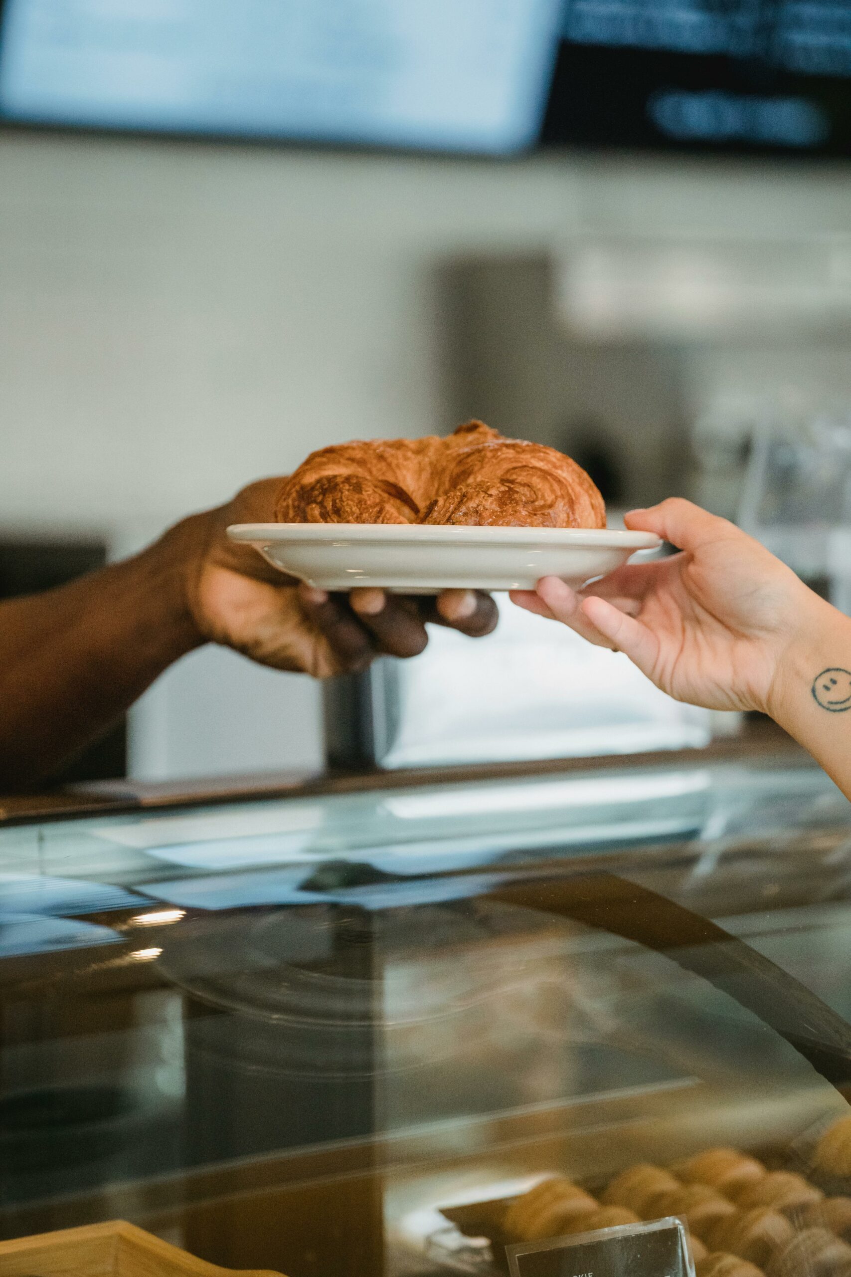 Croissant artisanal remis à un client lors d'une vente en boulangerie